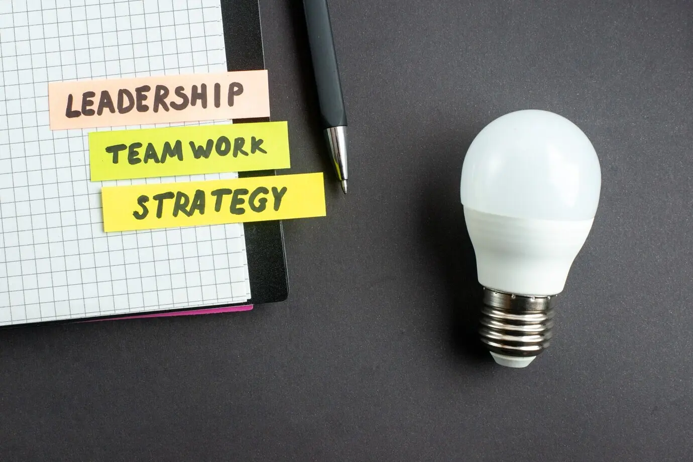 Вид сверху на заметку о бюджете в блокноте с ручкой на тёмной поверхности; бизнес, маркетинг, работа, командная работа, офис, лидерство, успех в работе.